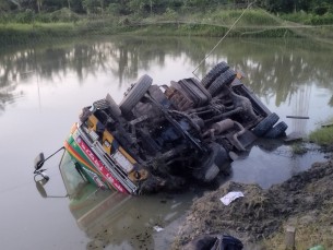 ভেদুরিয়া সড়কে পাল্লা দিতে গিয়ে ট্রাক উল্টে পুকুরে